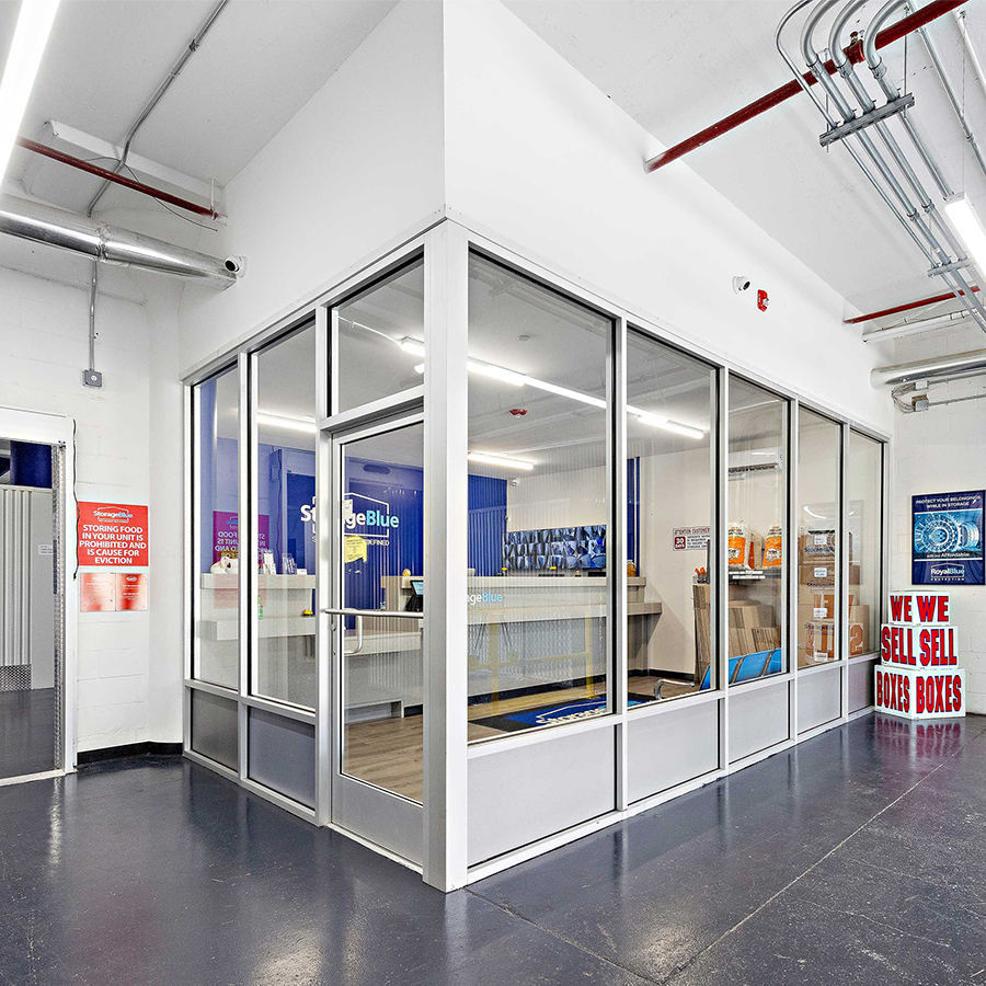 Glass-walled rental office and box display inside StorageBlue Ferry Street